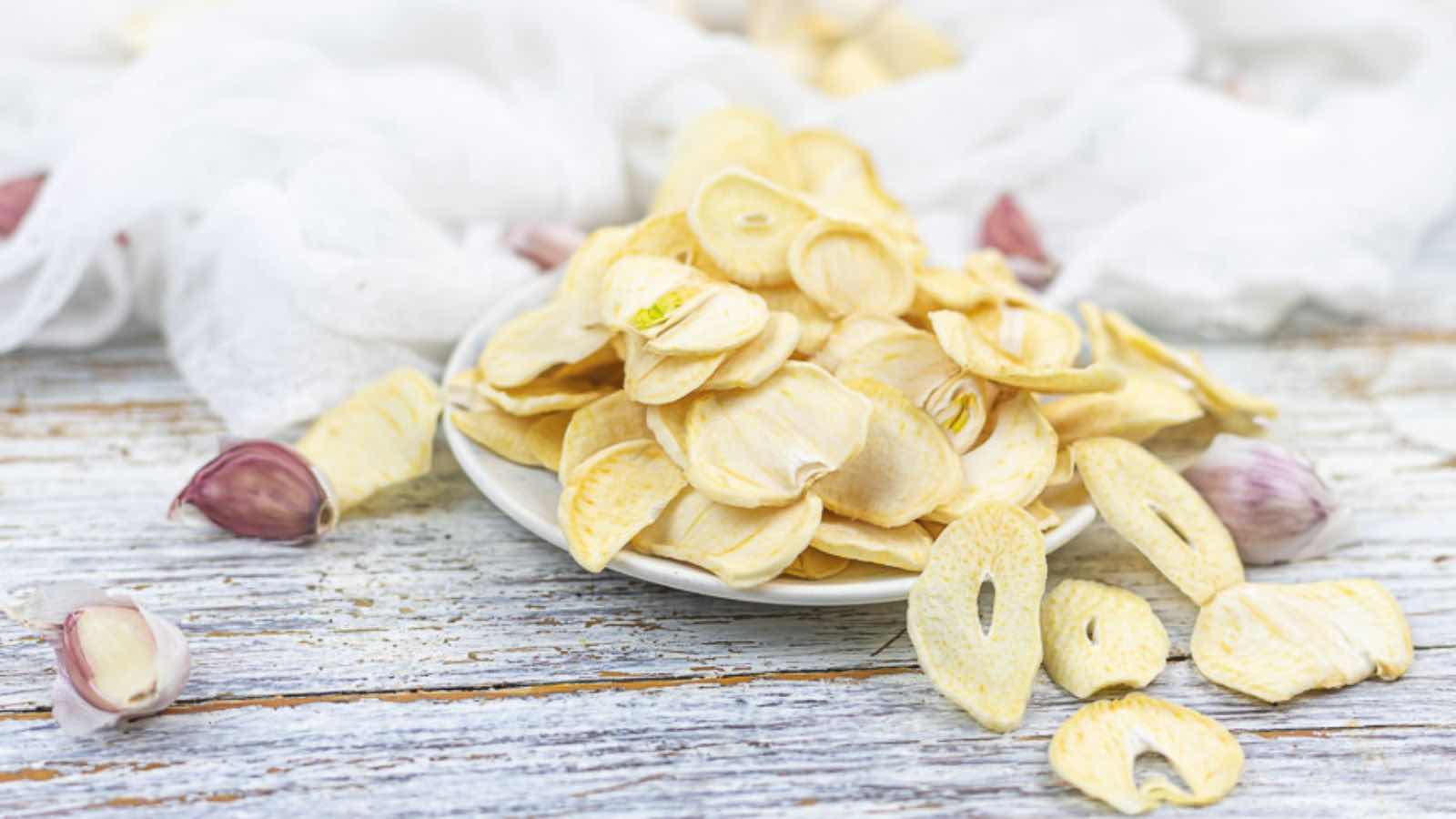 Garlic chips in a bowl on a wooden table.