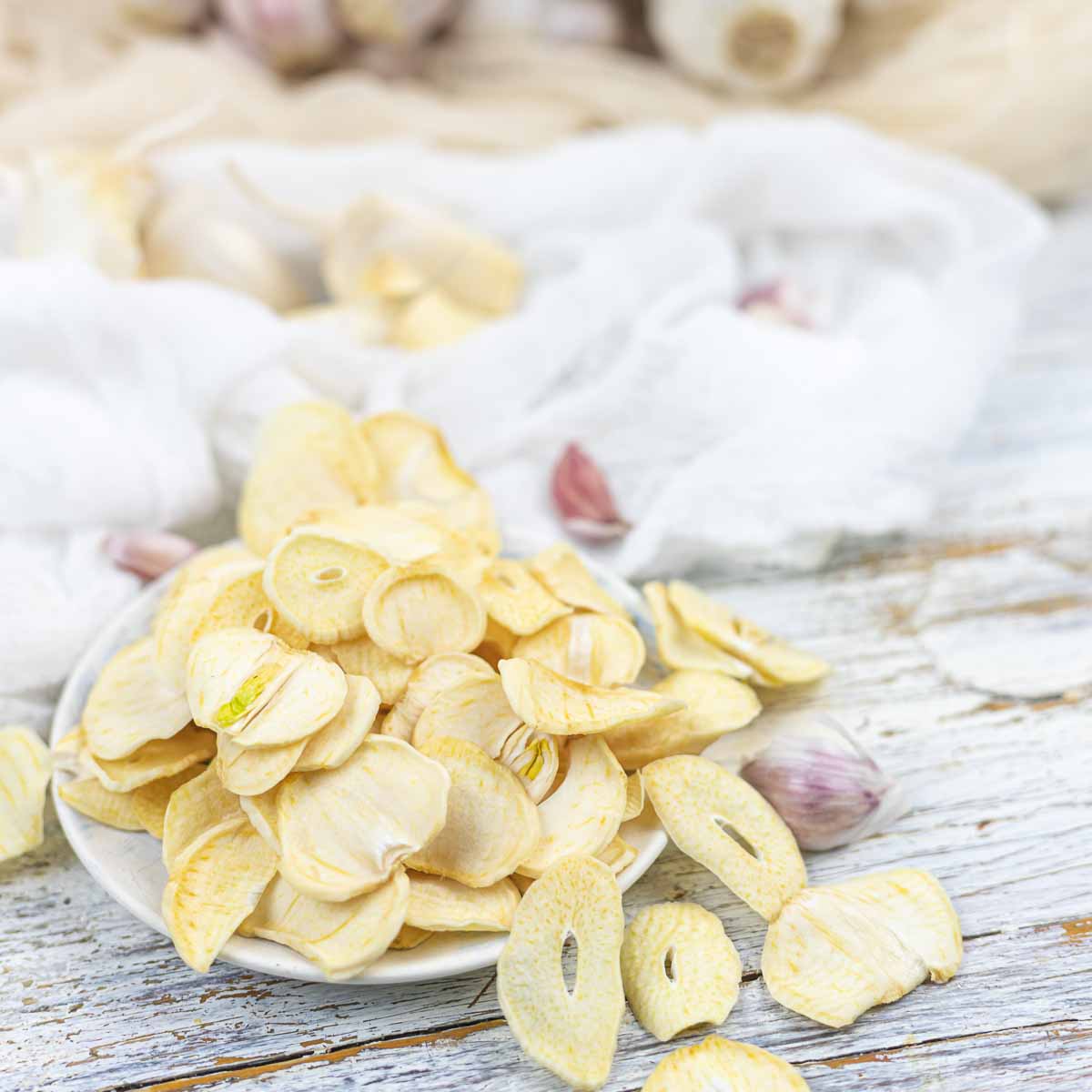 Garlic chips in a white bowl on a wooden table.