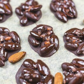 Chocolate covered almonds on a baking sheet.