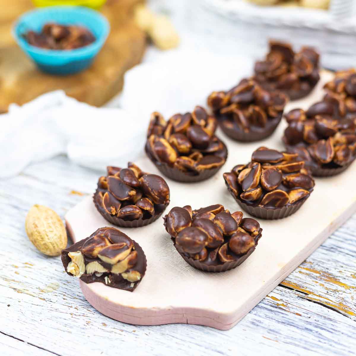 A tray of peanut clusters on a wooden table.
