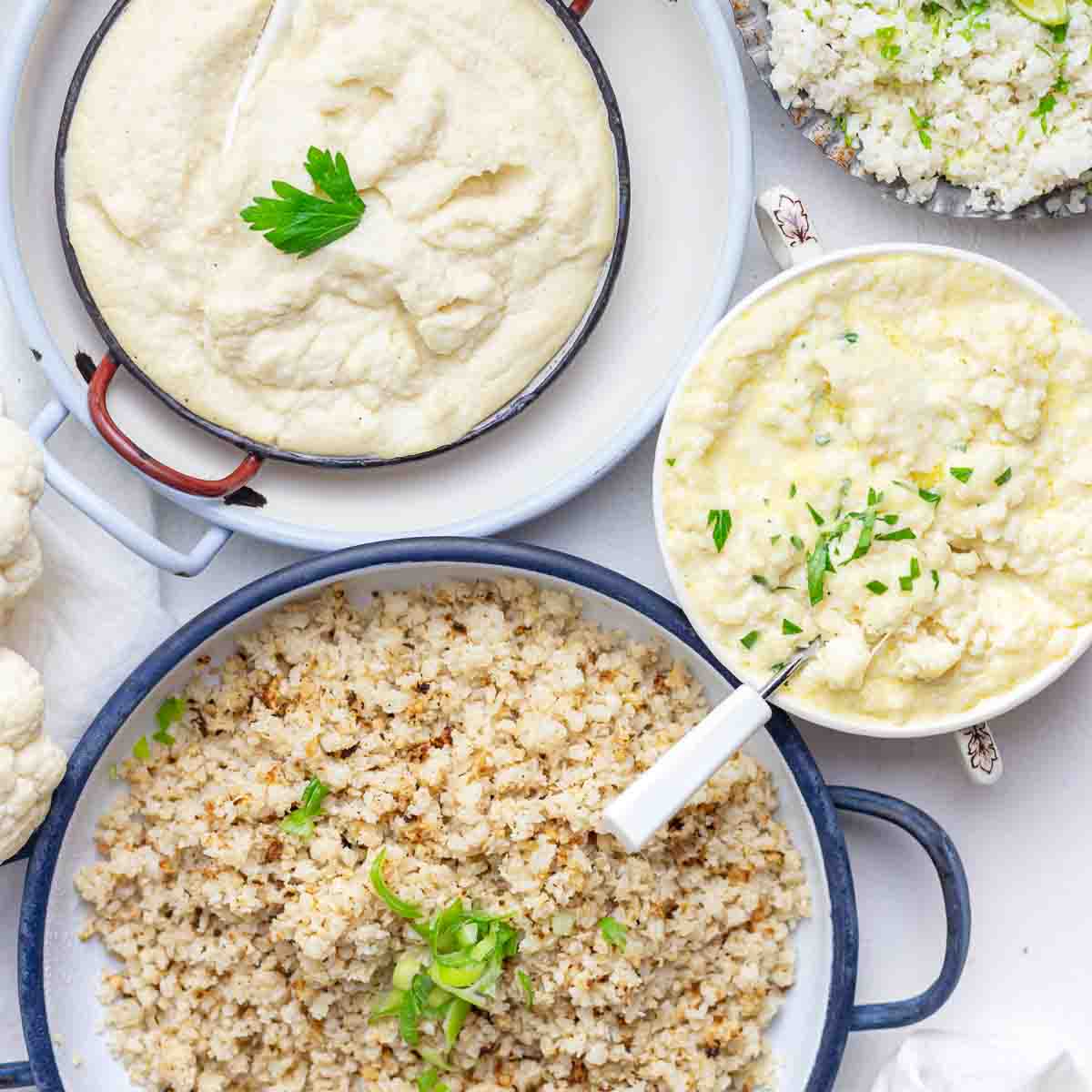 Plates of creamy mashed cauliflower and cauliflower rice, garnished with parsley and green onions, arranged on a table.