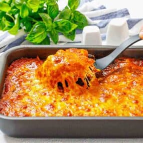 Golden baked eggplant parmesan casserole on table.