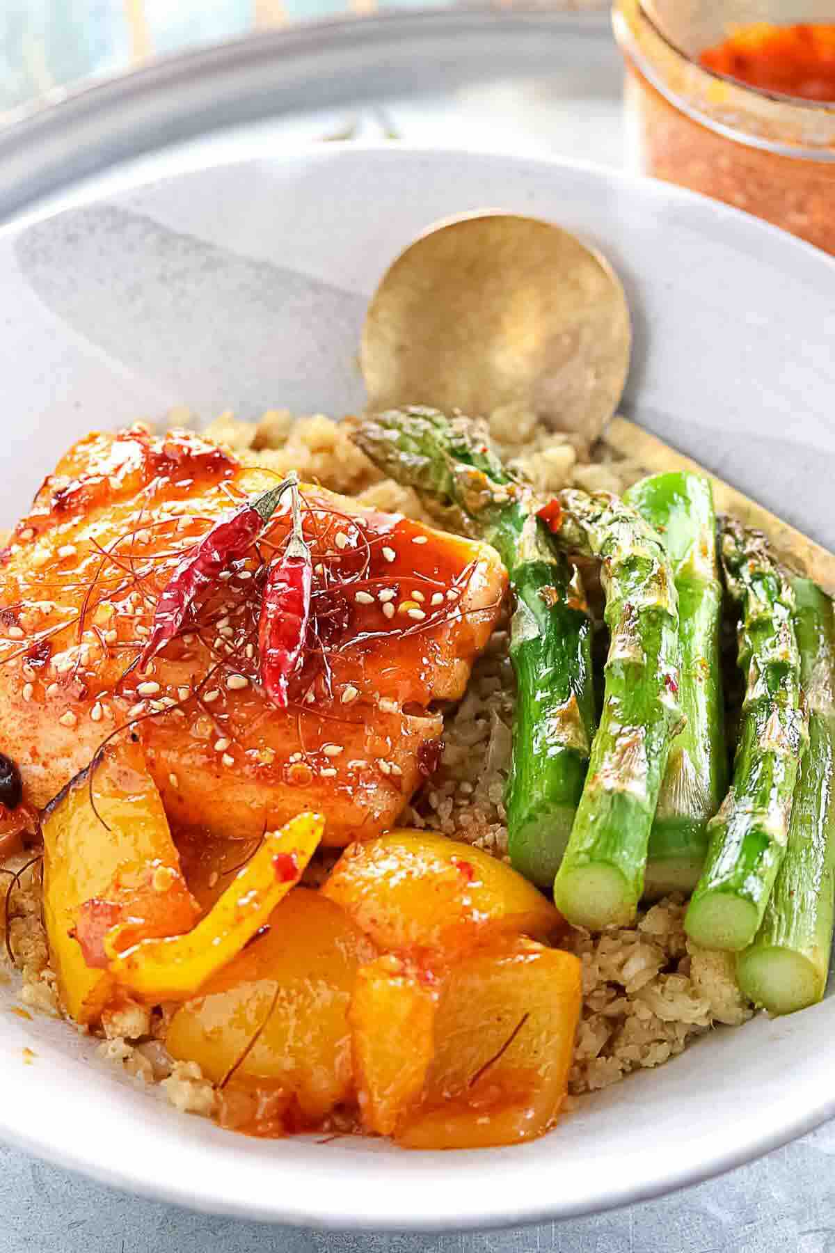 Salmon with asparagus and peppers over cauliflower rice.