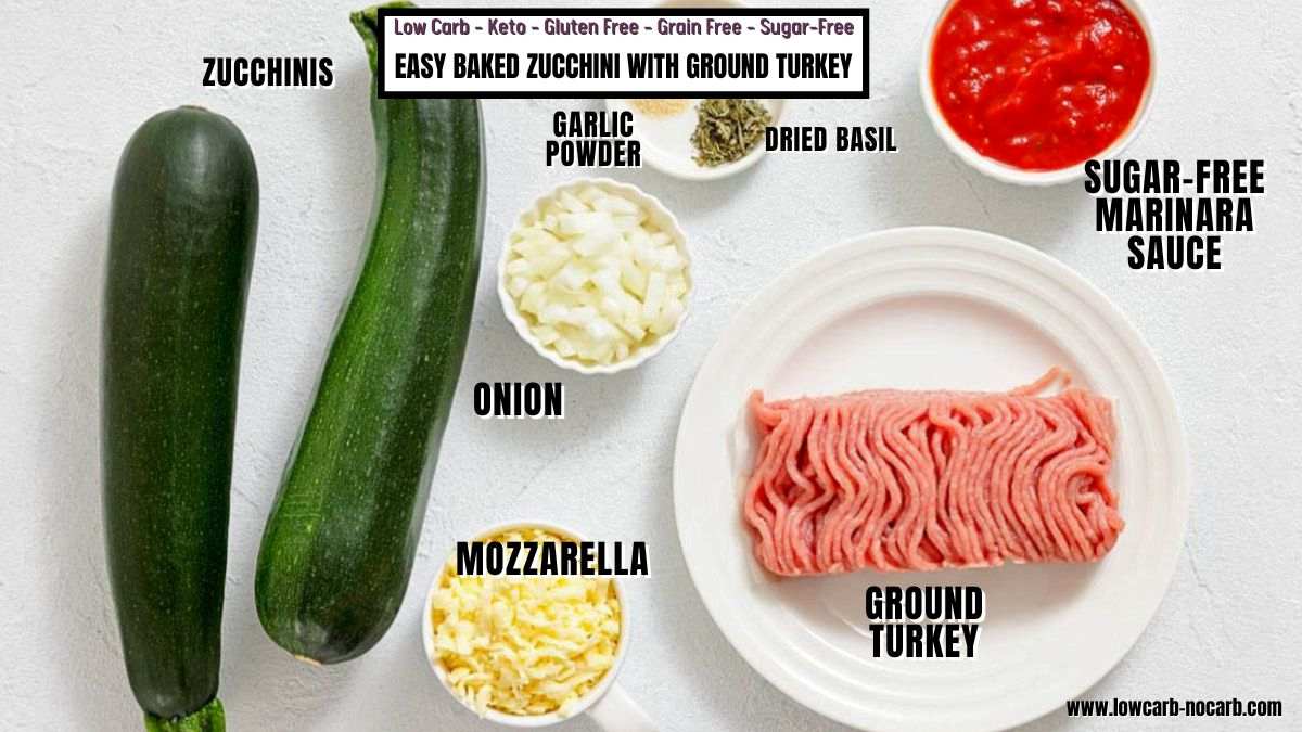 Ingredients for easy baked zucchini with ground turkey: zucchinis, onion, mozzarella, garlic powder, dried basil, ground turkey, and sugar-free marinara sauce arranged on a white surface.