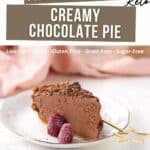A slice of creamy chocolate pie on a white plate, garnished with two raspberries, with text highlighting it as low carb, keto, gluten free, grain free, and sugar free.