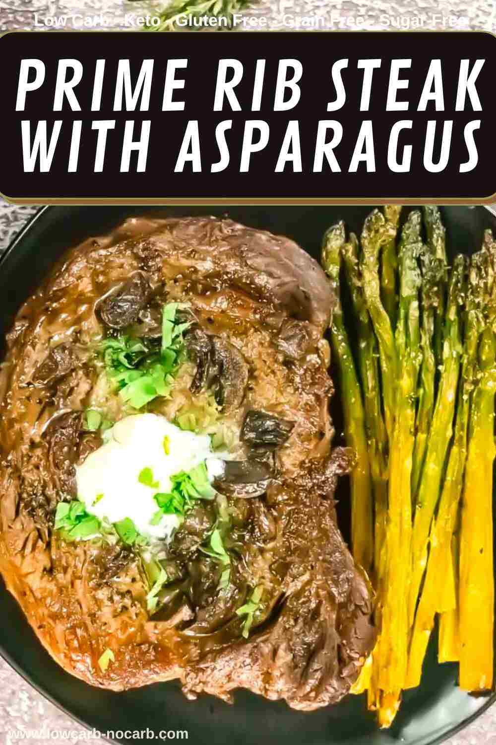 Prime rib steak topped with sour cream and chopped herbs, served with a side of roasted asparagus on a black plate.