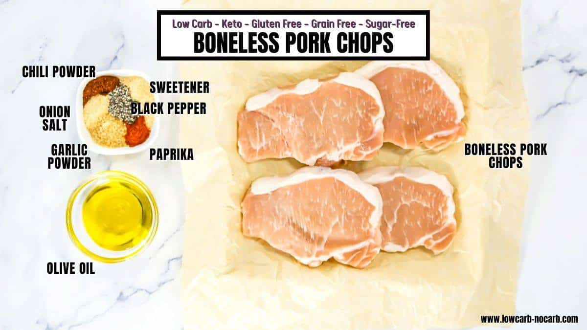 Three raw boneless pork chops on parchment paper, surrounded by small bowls of olive oil, spices, and seasonings, with ingredient labels for a low-carb pork chop recipe.